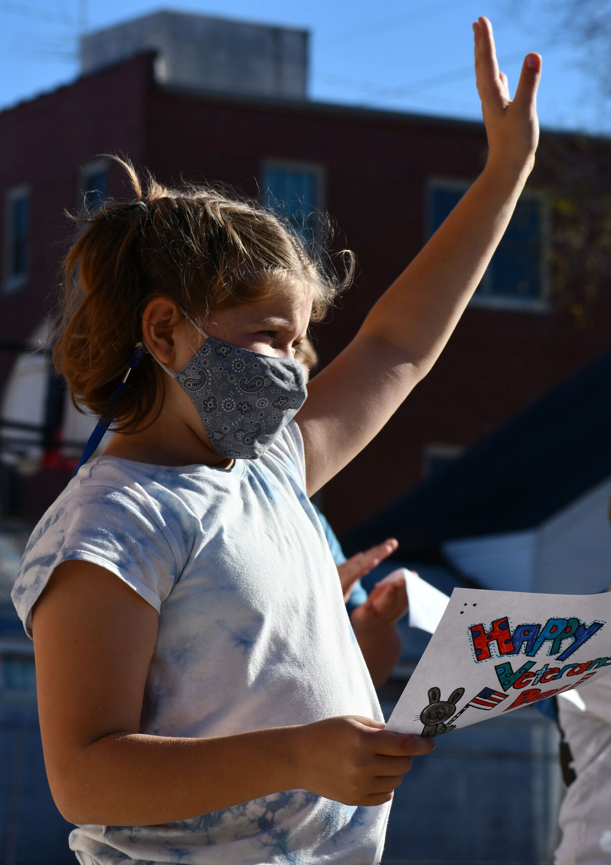 Zoey Downey waves to parade participants